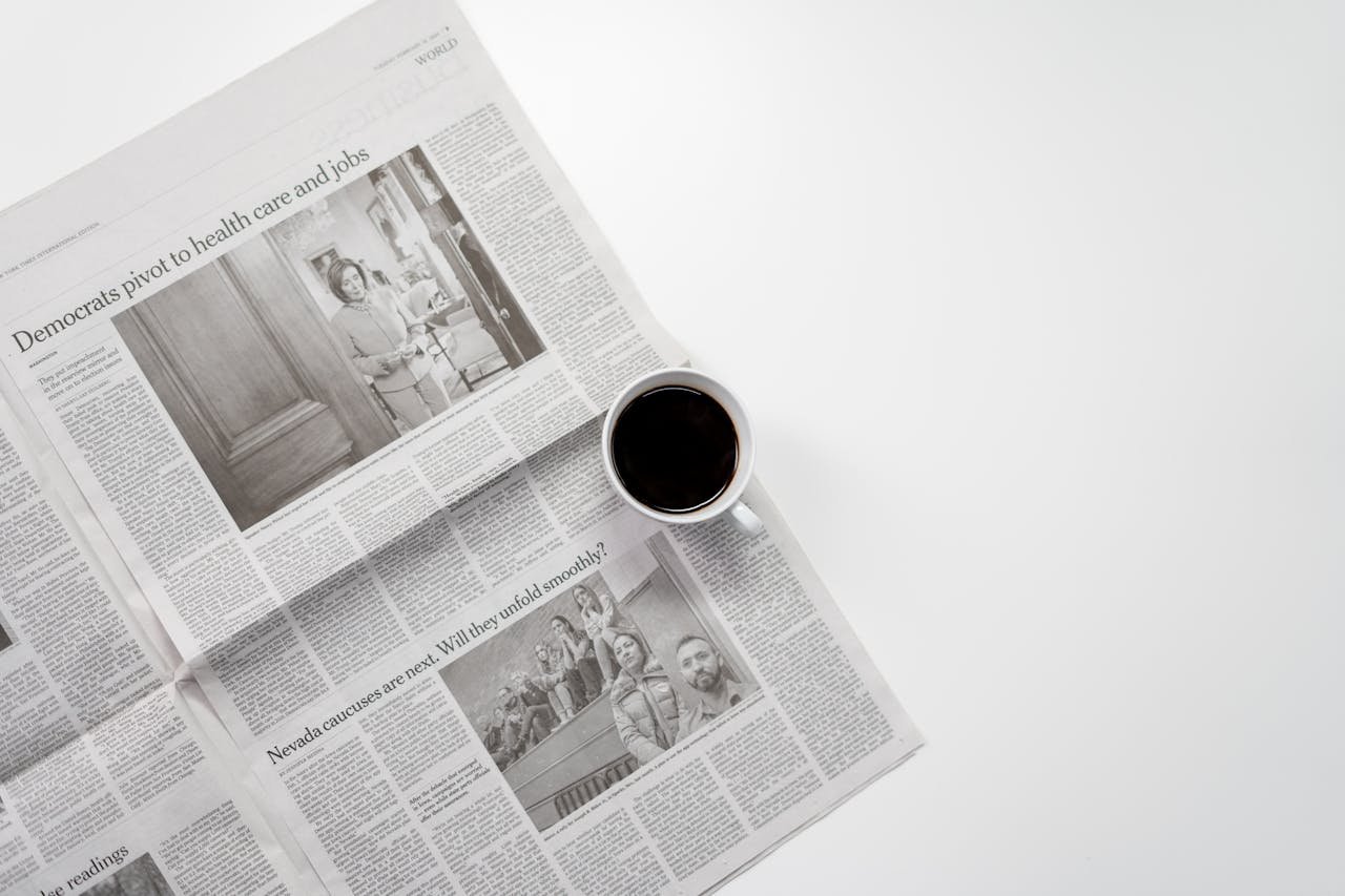 A fresh cup of coffee resting on a newspaper, perfect morning routine setup.